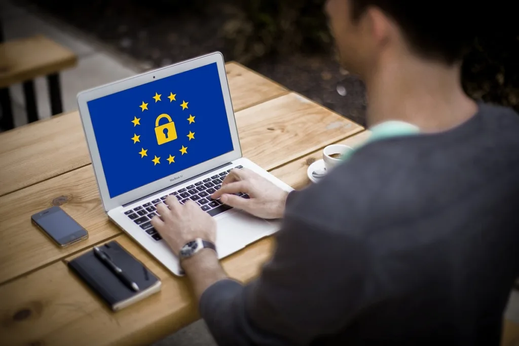 uomo al lavoro su un pc con logo UE. Per l'europa la cookie policy e la privacy sono importanti